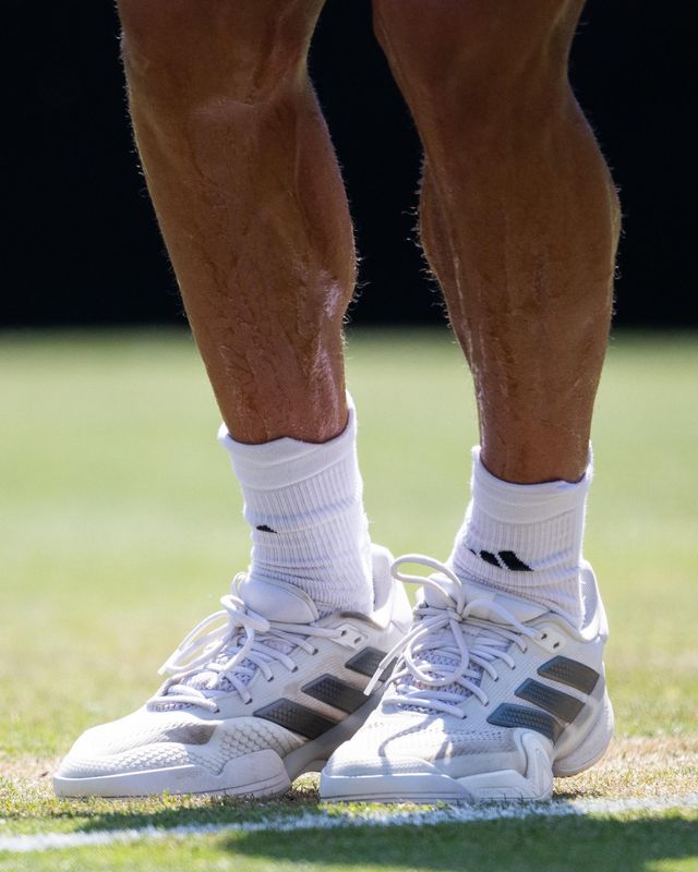 Tennis shoes on a grass court line