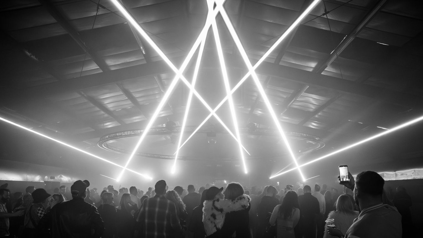 Laser beams over a concert crowd in black and white