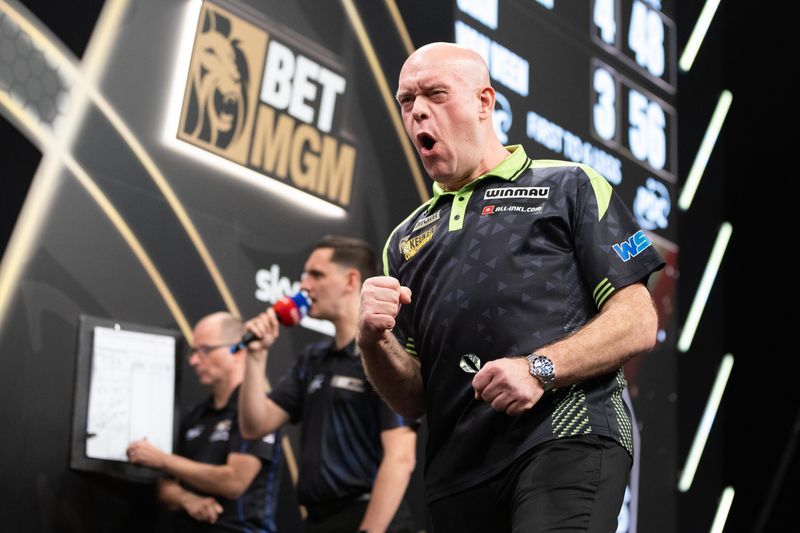 Darts player on stage at a televised event
