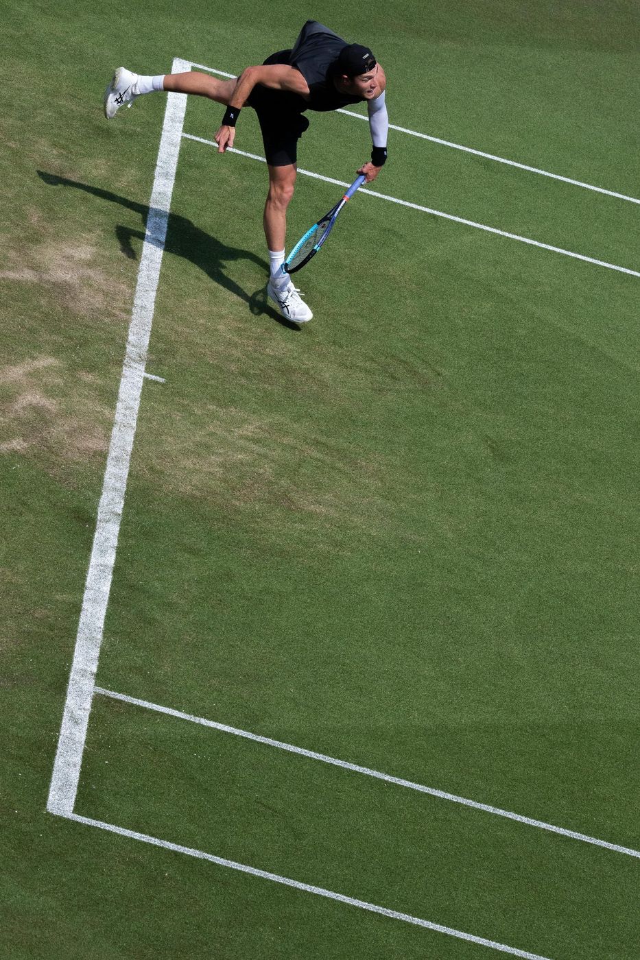 Overhead view of a tennis serve on a grass court
