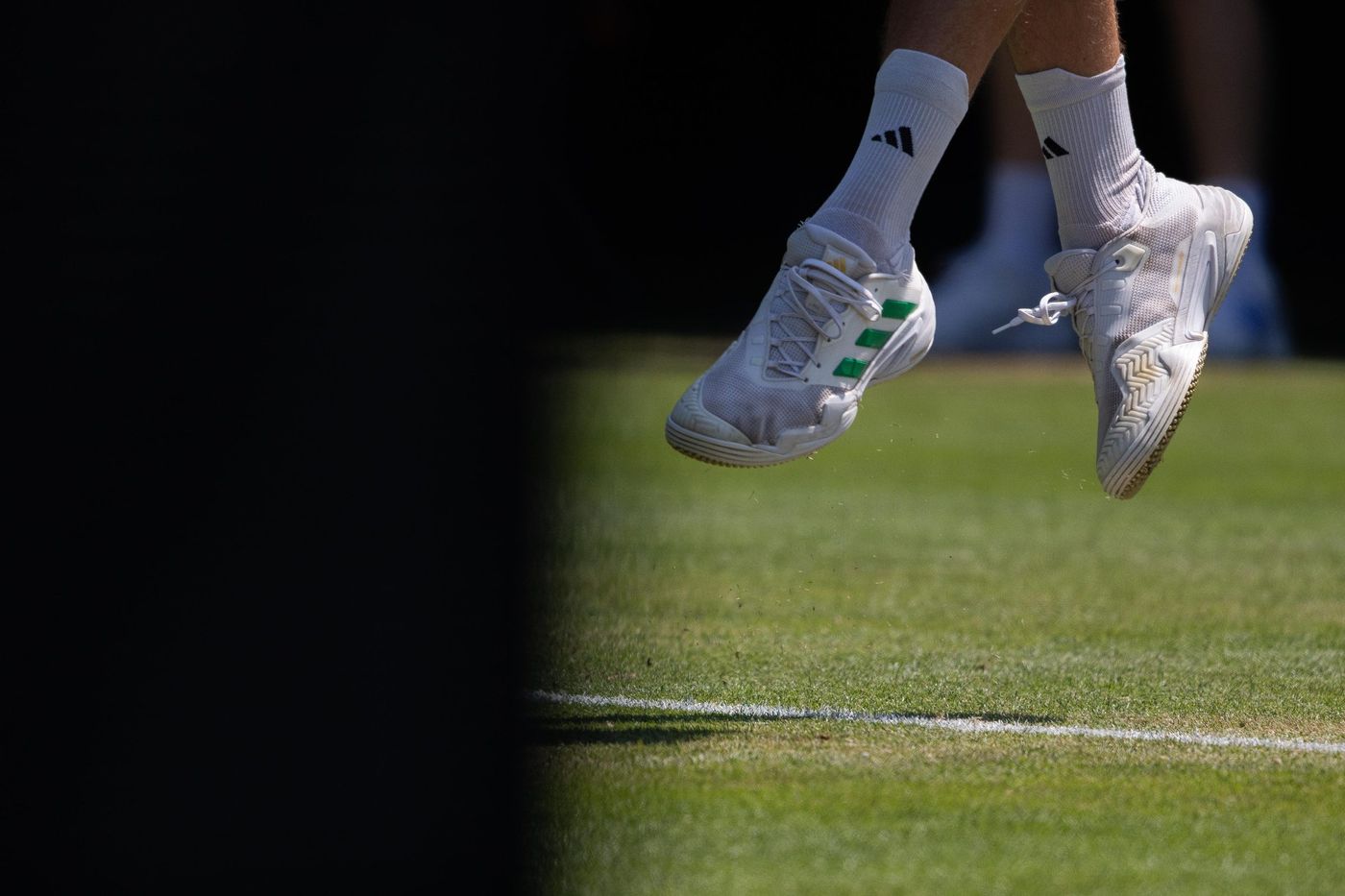 Tennis player jumping over the baseline