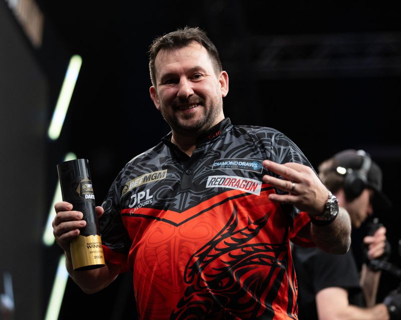 Darts champion holding a trophy
